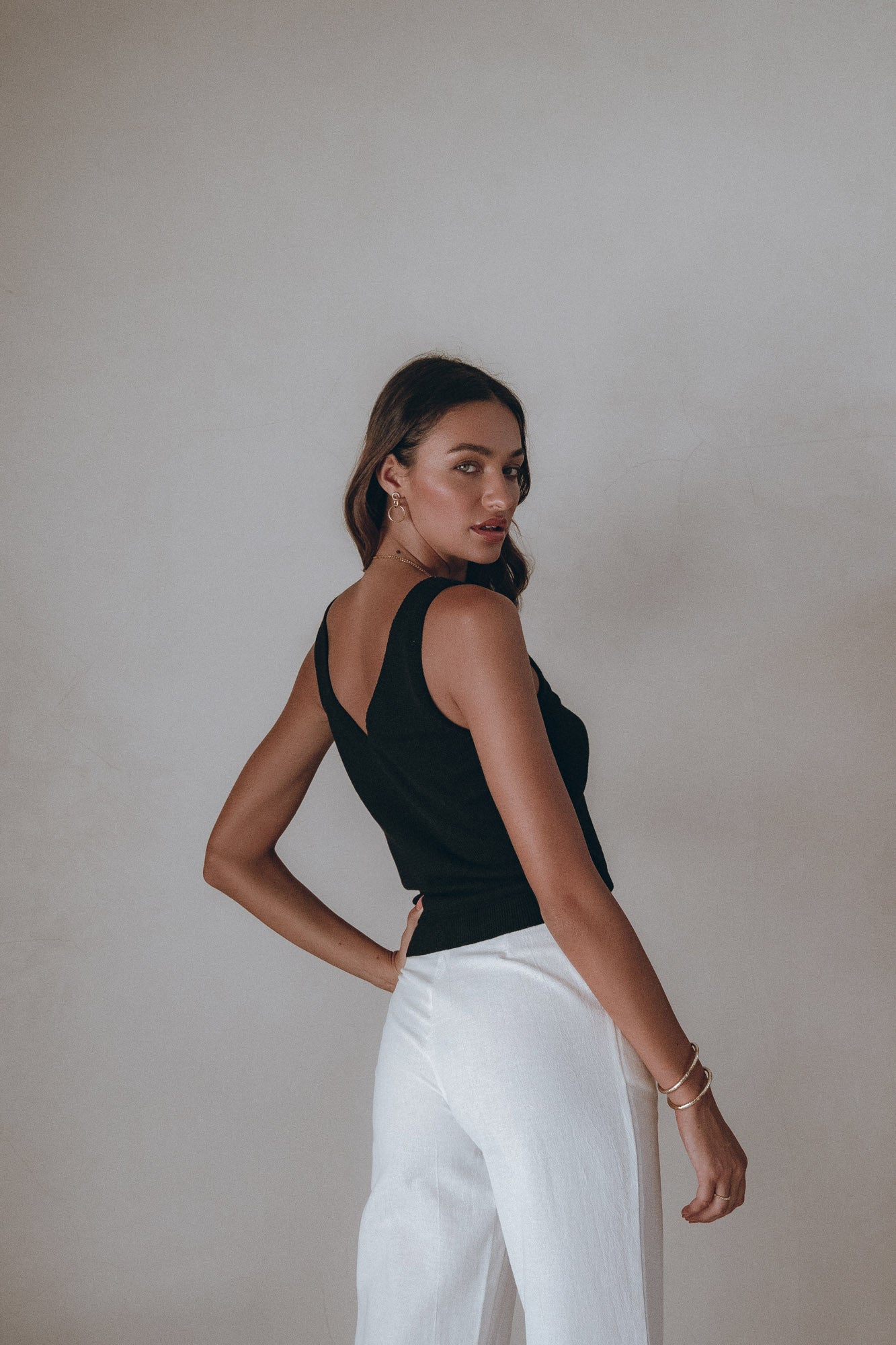 female model wears black top with white pant