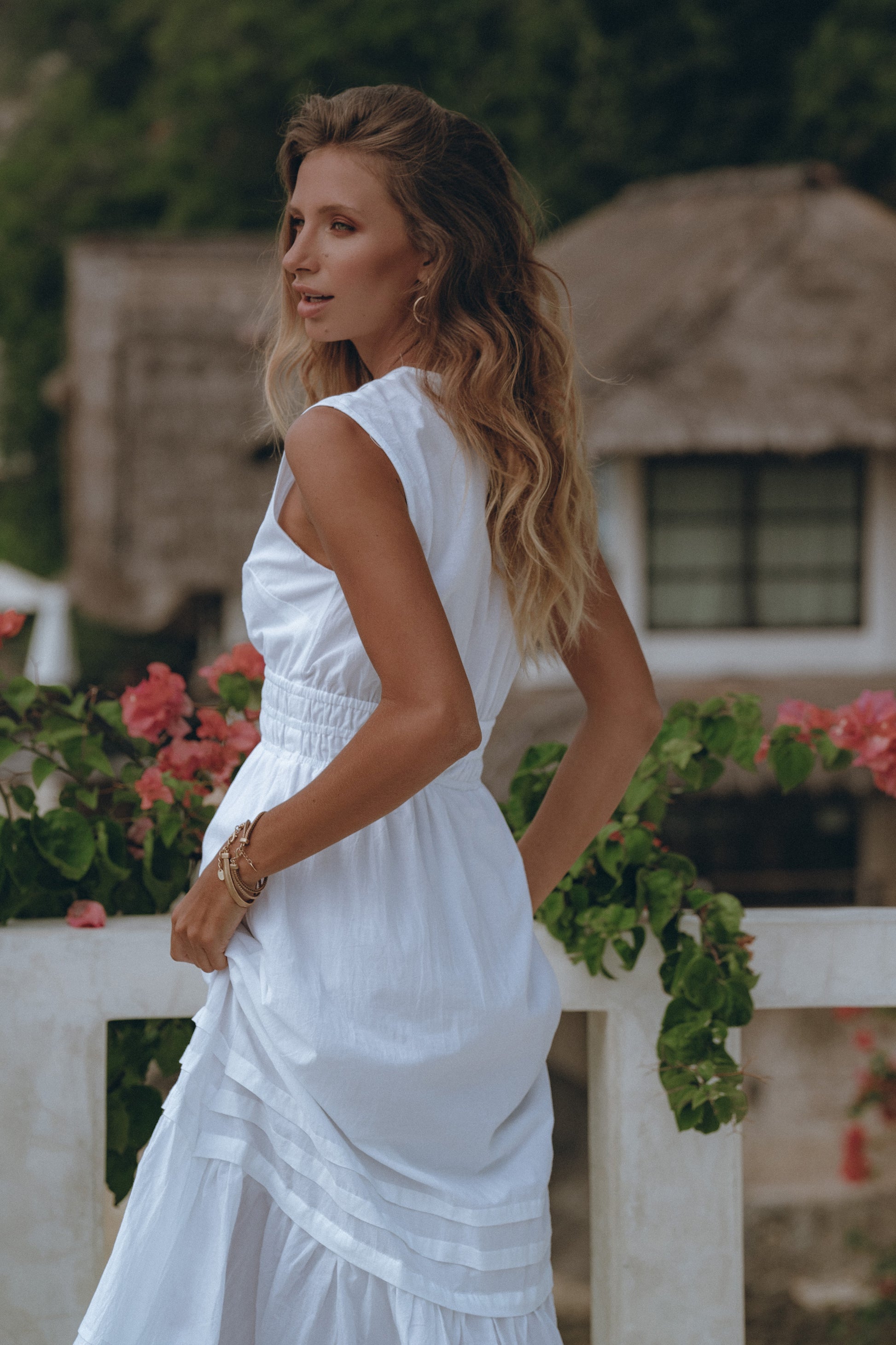 A model wore a long white dress walking on roof 
